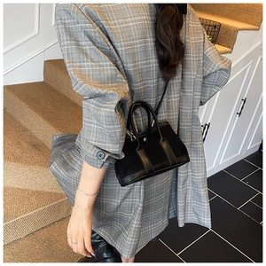 Close-up of a stylish black bucket bag with a mix of matte and glossy leather details
