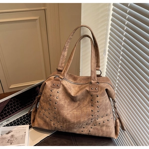 Détail d'un grand sac cabas marron vintage avec clous métalliques en similicuir souple