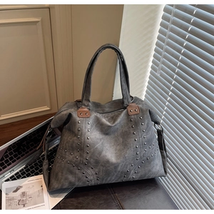 Détail du grand sac cabas à texture vintage avec clous argentés et garniture en cuir marron