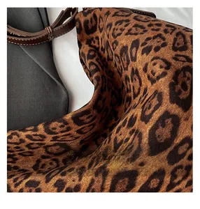 Dettaglio borsa tote leopardata con tracolla in pelle marrone e cuciture rinforzate