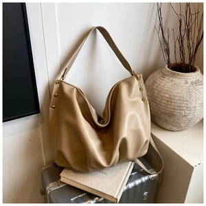 Detail of soft lychee leather hobo bag with vintage gold rivets and wide strap