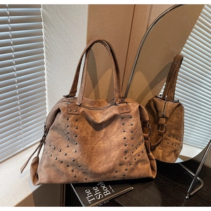 Détail du grand sac cabas marron vintage avec rivets métalliques et texture cuir élégante