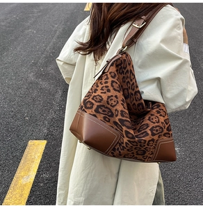 Dettaglio della grande borsa tote leopardata con angoli in pelle marrone e cuciture bianche