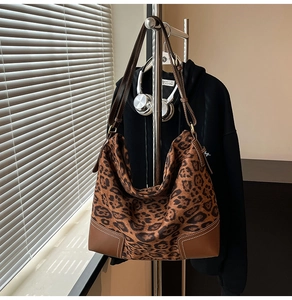 Dettaglio della borsa tote leopardata con base in pelle marrone e cuciture