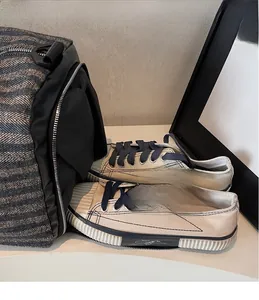 Vue détaillée du compartiment à chaussures latéral d'un sac de sport gris foncé à chevrons