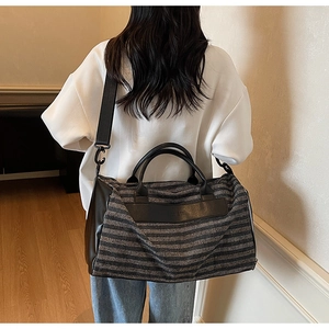 Détail d'un grand sac de sport en toile rayée avec compartiment chaussures et bandoulière