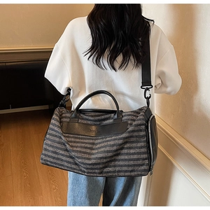 Sac de sport rayé avec poche zippée latérale porté en bandoulière par un mannequin