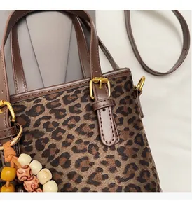 Détail du sac seau léopard avec ferrures dorées et breloques en perles de bois colorées
