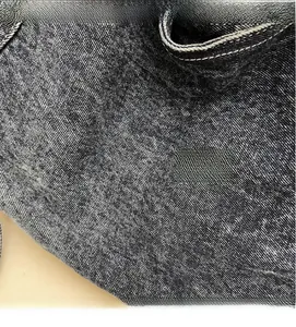 Close-up of durable dark wash denim fabric featuring precise white double stitching details