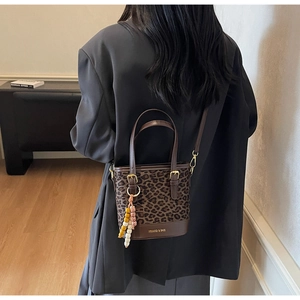 Gros plan détaillé d'un sac seau léopard avec breloque perlée sur un mannequin