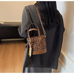 Détail du sac seau léopard avec finitions en cuir marron et pendentif en perles