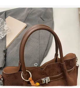 Vue détaillée du sac cabas en daim marron foncé avec poignées en cuir et anneaux argentés