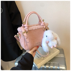Dettaglio della borsa a secchiello in camoscio rosa con bordo in lana e ciondolo