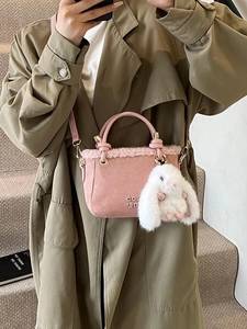 Borsa a secchiello in camoscio rosa con ciondolo a coniglio e tracolla lunga invernale