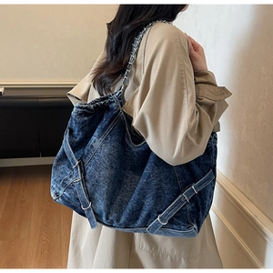 Detailed view of large vintage denim tote bag with metal chain strap and side buckles