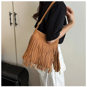 Brown frosted faux suede shoulder bag with long fringes and adjustable strap shown on model