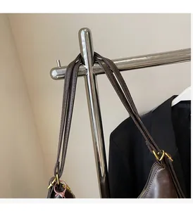 Detail of dark brown leather tote bag with gold metal rings and comfortable handles