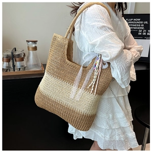 Close-up of woven straw tote bag with lace ribbon and colorful bead details