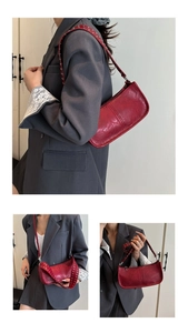 Detail of adjustable shoulder strap with silver rivets on vintage red square bag