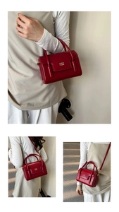 Détail d'un sac à main en cuir verni rouge foncé avec poignée et bandoulière amovible
