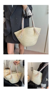 Detailed close-up of woven straw tote bag with colorful braided handles and fringe