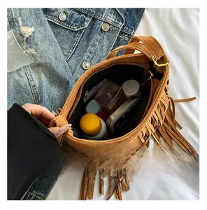 Detail showing internal capacity of brown suede fringe crossbody bag with essentials
