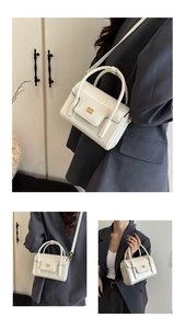 Détail du mini sac boîte blanc crème avec logo en métal doré et poignée ronde