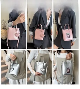 Detail view of mini tote phone bags with glossy finish, transparent card slot and heart charm