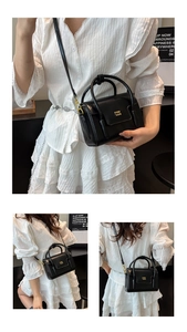 Détails du mini sac à main noir minimaliste en cuir avec logo doré et bandoulière fine
