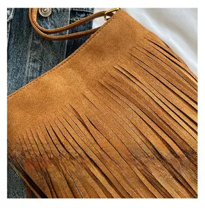 Close-up of brown suede crossbody bag with layered long fringes and premium texture