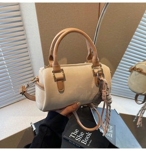 Detail of beige velvet Boston bag with leather handles and decorative tennis racket charm