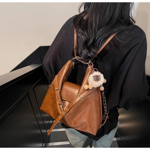Detailed back view of a brown vintage PU leather tote bag with a white lamb charm