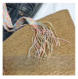 Detailed macro view of woven straw tote texture with colorful fringe and boho tassels
