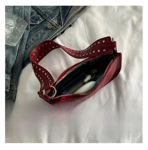 Detail showing red leather crossbody bag interior capacity with silver rivet strap