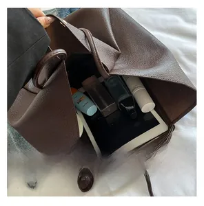 Detail view of spacious brown leather tote interior showing tablet and cosmetic storage