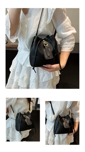 Detail of black lychee grain bucket bag with gold hardware and drawstring closure