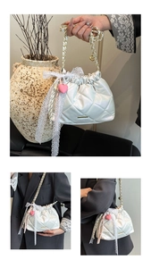 Detail view of quilted leather bucket bag with lace bows and pink heart charm