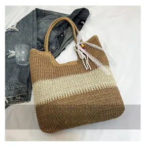 Detail of hand-woven straw tote with contrast stitching and decorative lace pendant