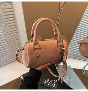 Detail of pink Boston bag with badminton racket pendant and textured surface