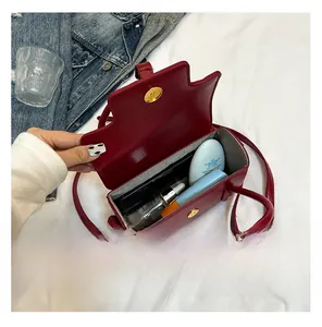Vue intérieure du sac bandoulière en cuir rouge montrant l'espace pour le maquillage