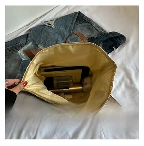 Spacious interior of woven straw tote bag showing books and cosmetics storage