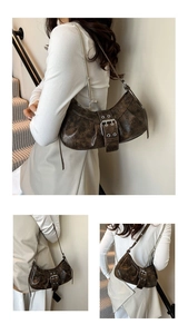 Close-up of vintage dark brown crescent bag with silver buckle and faux leather texture