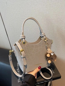 Borsa a secchiello grigia in pelle con manico superiore e ciondolo in peluche marrone
