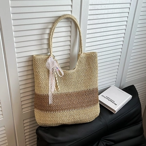 Straw tote bag with pink lace ribbon and brown two-tone woven design for beach vacations