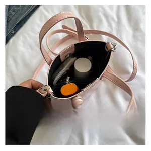 Interior view of small pink patent leather crossbody bag showing phone storage space