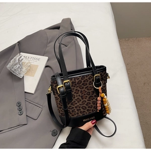 Détail d'un sac seau léopard avec texture en peluche et breloque en perles colorées