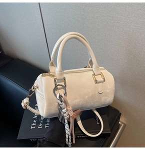Detailed close-up of cream Boston bag with soft matte texture and golden hardware