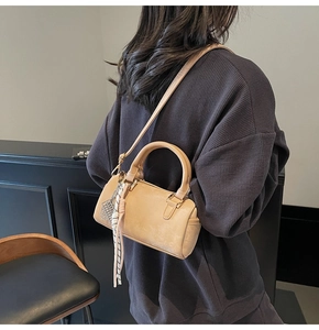Detail of beige Boston bag with geometric silk scarf and elegant metal pendant