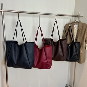Detailed view of large tote bags in four colors hanging on a modern metal display stand