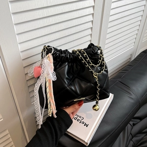 Minimalist black quilted chain bucket bag with lace ribbon and heart charm accessory